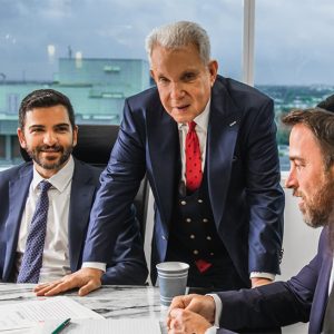 Three attorneys discussing family law strategies in a modern office setting, emphasizing collaboration and legal expertise for clients in Fort Lauderdale.